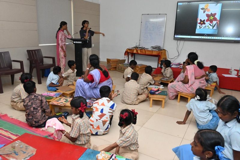 Shruti Arvind presenting to children and teachers seated at low tables